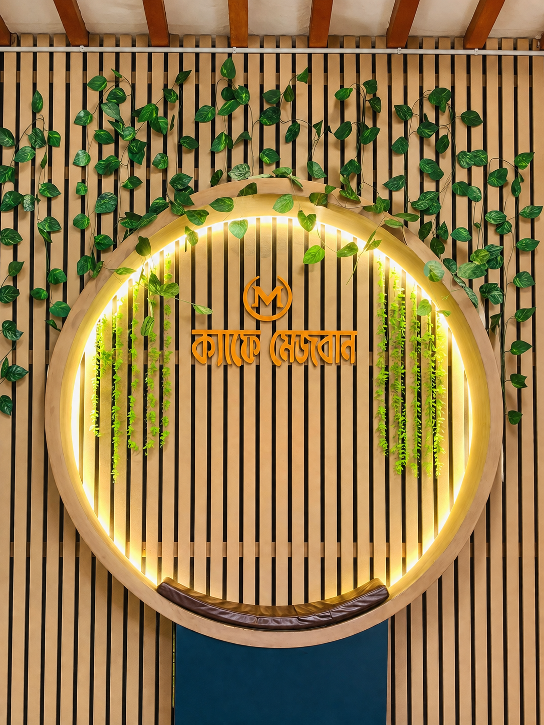 The living wall and glowing circular signage inside Cafe Mezban